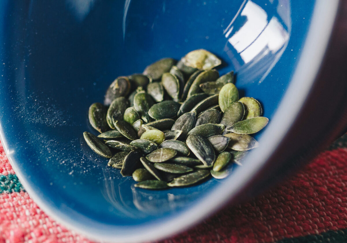 Green pumpkin seeds / pepitas in a blue bowl